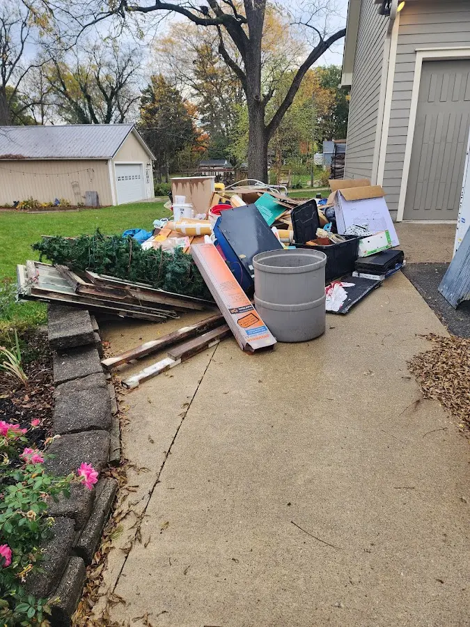 Dumpster being loaded with debris for 12 Yard Dumpster Rental in Arlington